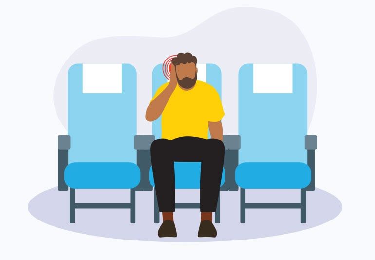 Person on an airplane holding their ear